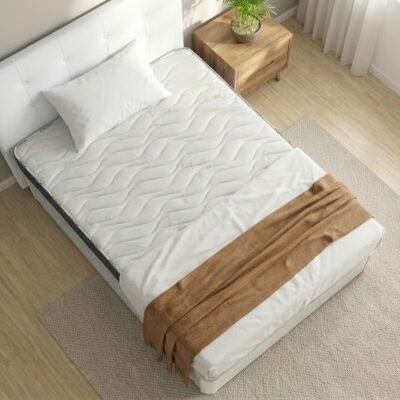 Vista aérea de una cama completa del "Pack Nature". Muestra un canapé abatible blanco con cabecero tapizado a juego, el colchón viscoelástico Eco Bambú, una almohada blanca y una manta tejida color marrón madera sobre sábanas blancas en un dormitorio luminoso.