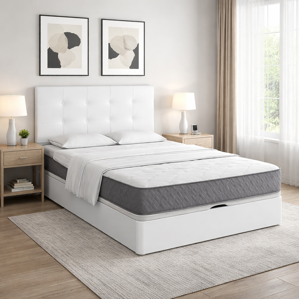 Cama de matrimonio con colchón gris de alta calidad sobre canapé blanco, vestida con sábanas blancas y sábana superior doblada a los pies de la cama, en dormitorio moderno minimalista con mesillas de madera y luz natural